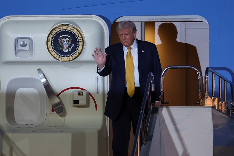 Donald Trump waves as he gets off Air Force One.