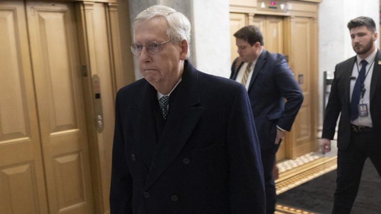 Mitch McConnell walking through the halls of Congress. He is legit sulking in this photo.