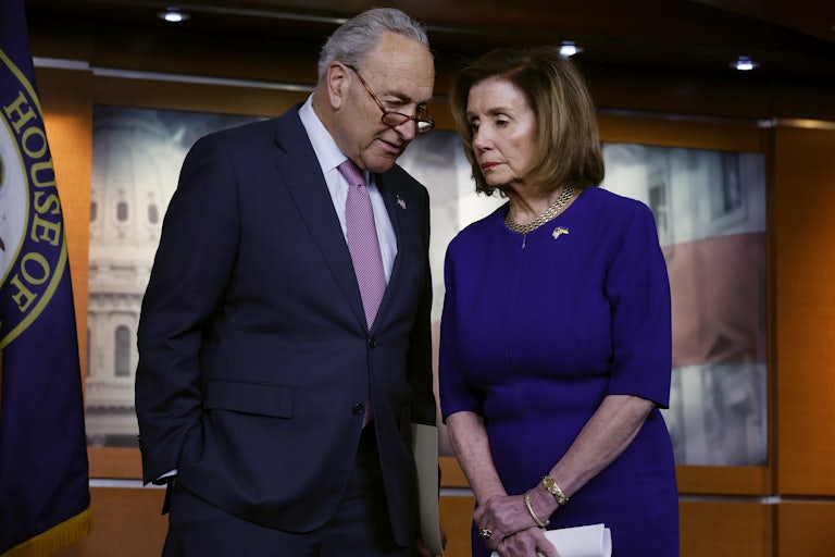 Senate majority leader Chuck Schumer and House Speaker Nancy Pelosi confer with each other.