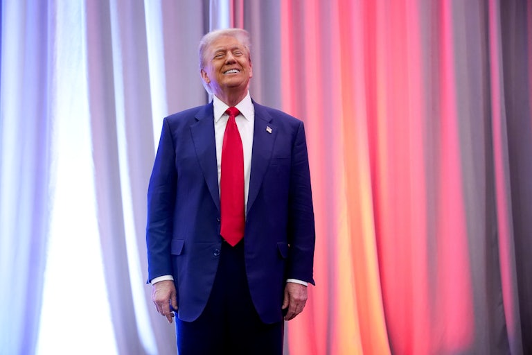 Donald Trump stands and smiles