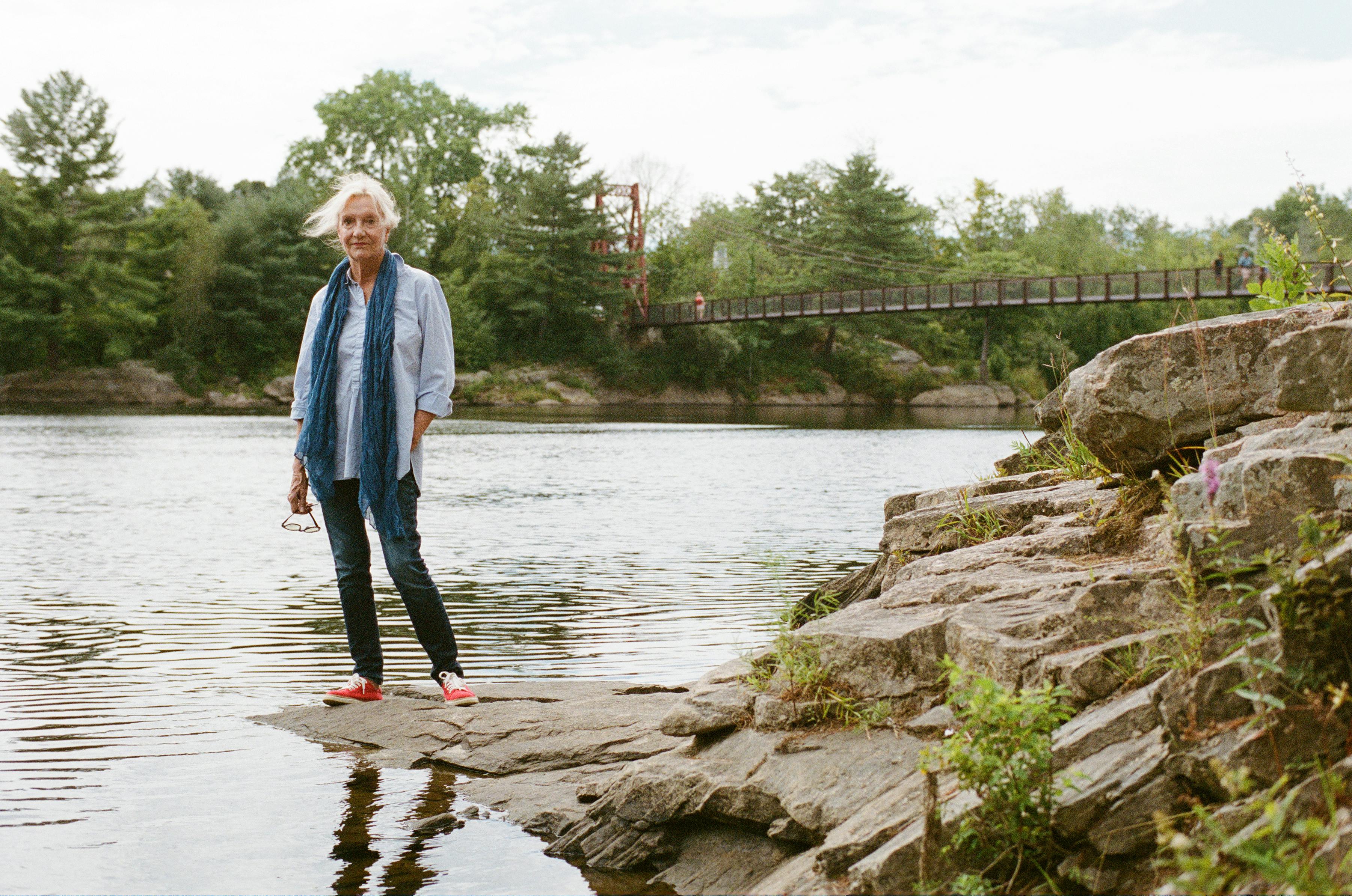Elizabeth Strout stands in front of the Androscoggin River in Topsham, Maine in 2022