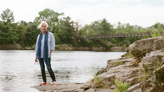 Elizabeth Strout stands in front of the Androscoggin River in Topsham, Maine in 2022