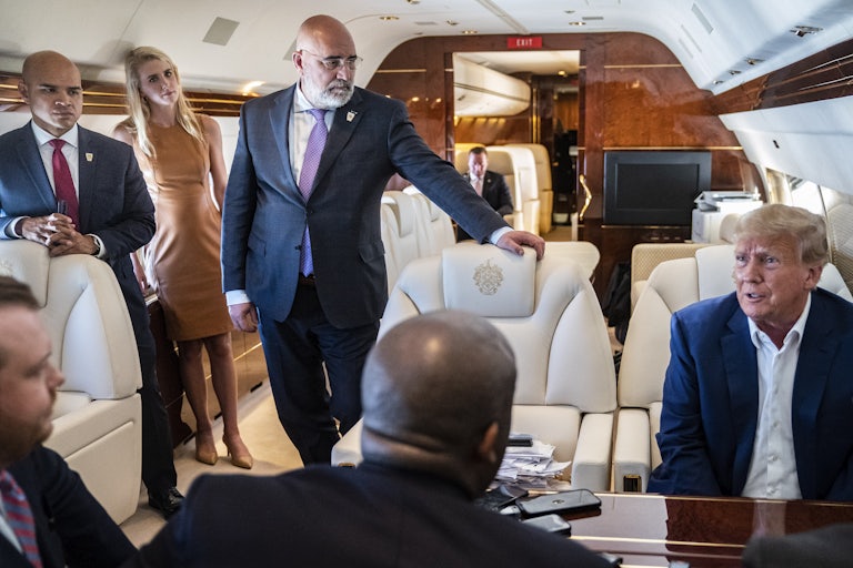 Walt Nauta, aid to former President Donald Trump, and Chris LaCivita listen as former President Donald Trump speaks with reporters and staff on his airplane, known as Trump Force One.