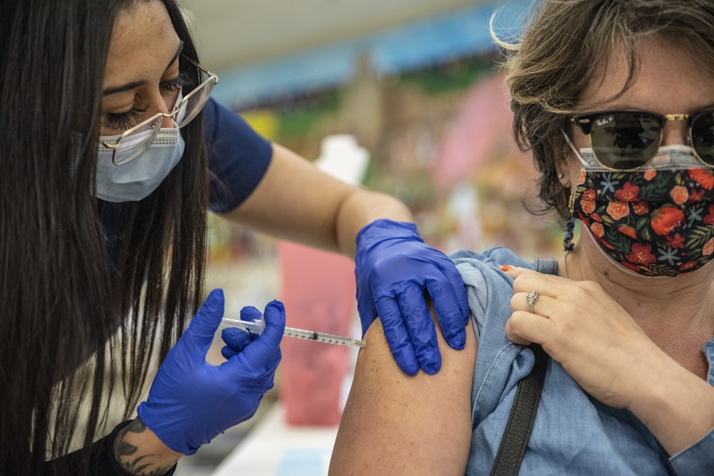 A woman receives her second Moderna COVID-19 vaccine at a vaccination site at a senior center in San Antonio, Texas