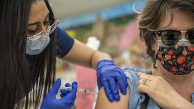 A woman receives her second Moderna COVID-19 vaccine at a vaccination site at a senior center in San Antonio, Texas