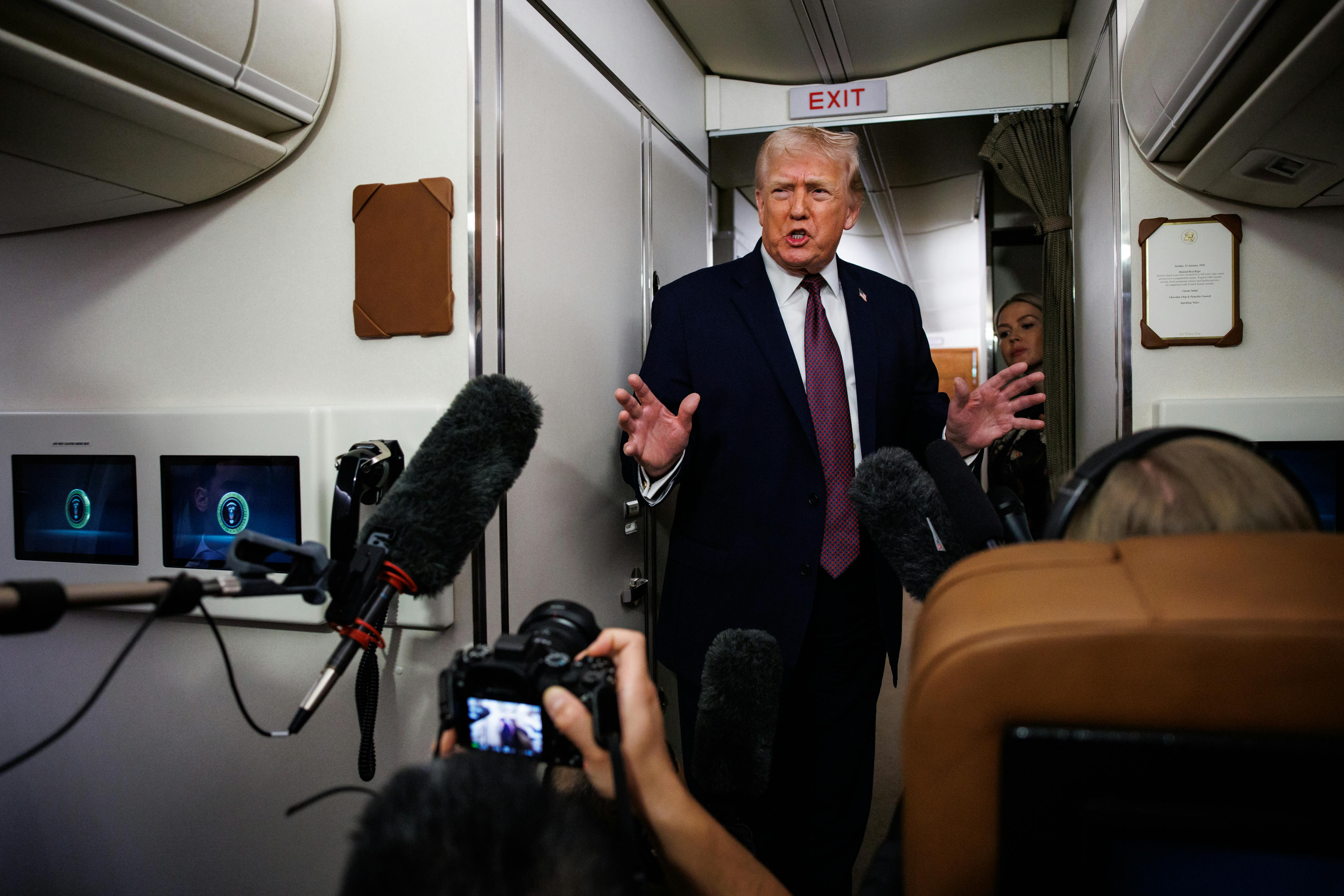 Donald Trump speaks to reporters aboard Air Force One.