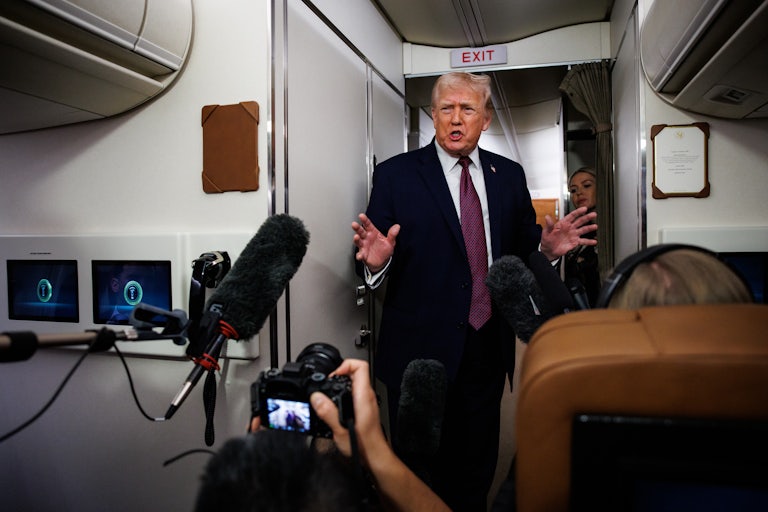 Donald Trump speaks to reporters aboard Air Force One.