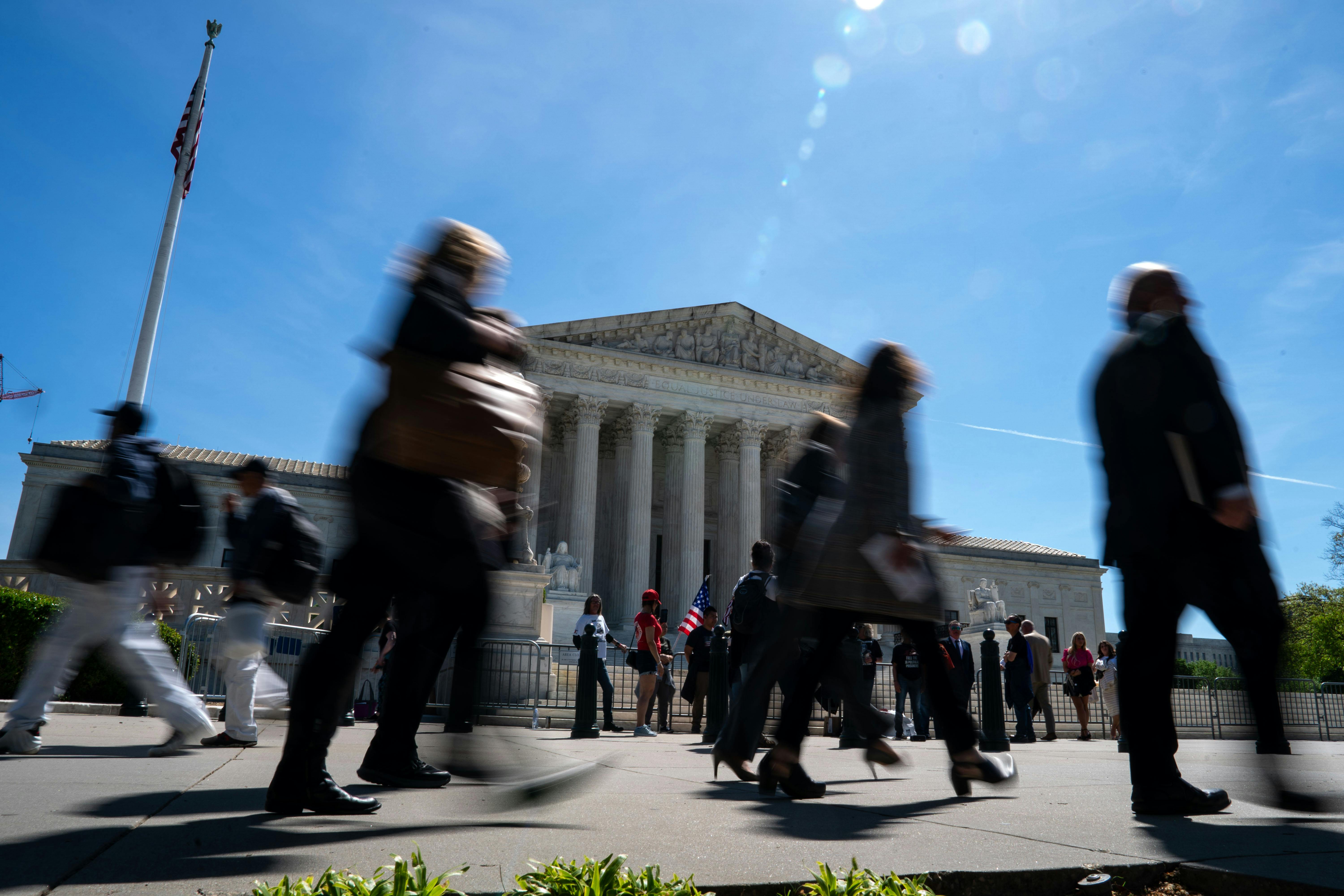 People walk in front of the Supreme Court building.