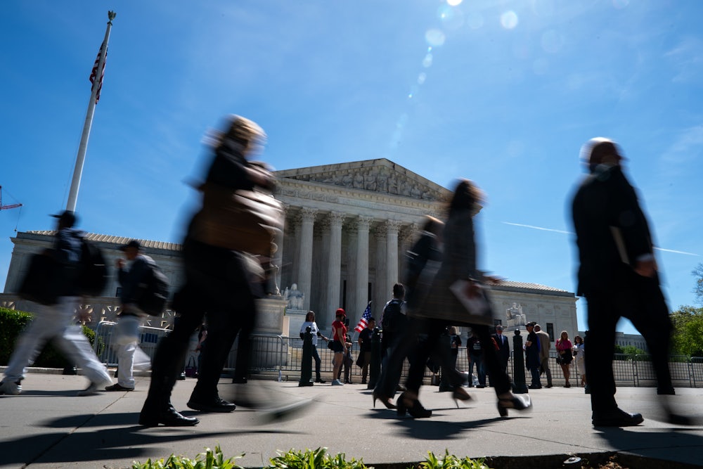 People walk in front of the Supreme Court building.