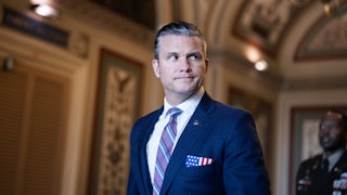 Defense Secretary Pete Hegseth looks to the side while walking in the Capitol