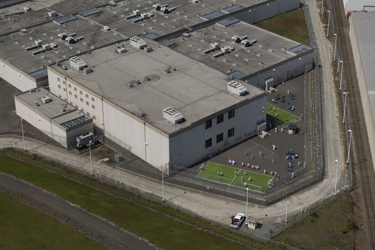 An aerial view of detainees outdoors at an ICE center.