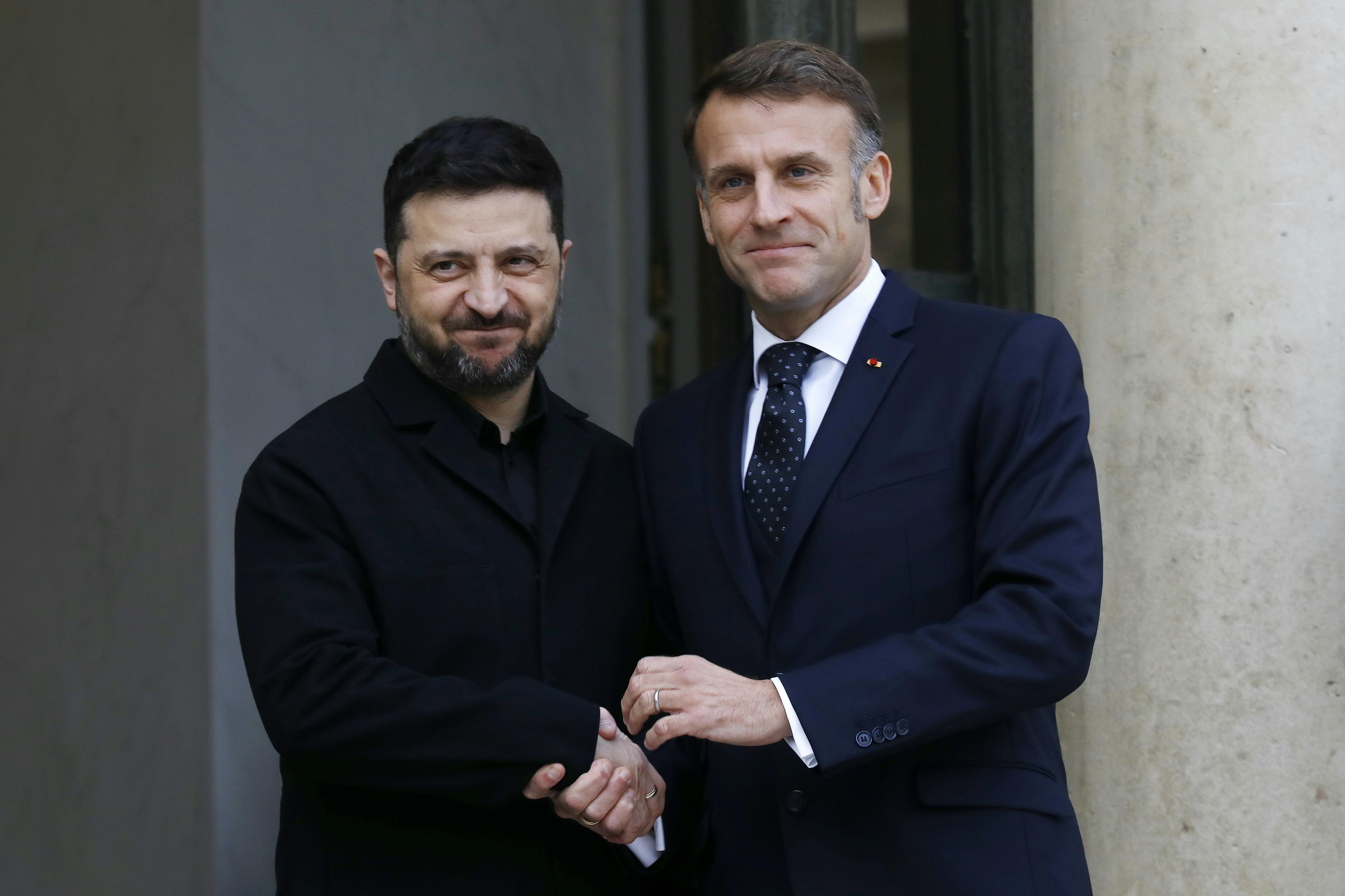 Ukranian President Zelenskiy and French President Macron shake hands.