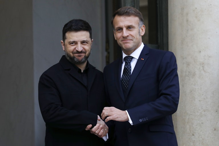 Ukranian President Zelenskiy and French President Macron shake hands.