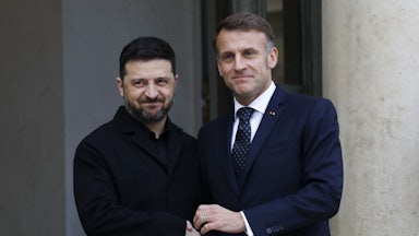 Ukranian President Zelenskiy and French President Macron shake hands.