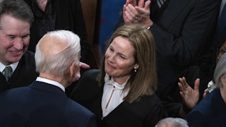 Biden greets Coney Barett, surrounded by people.