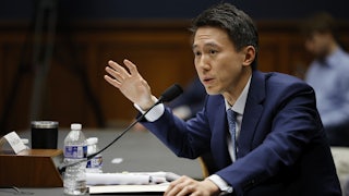 TikTok CEO Shou Zi Chew testifies before a mic. He raises his right hand.