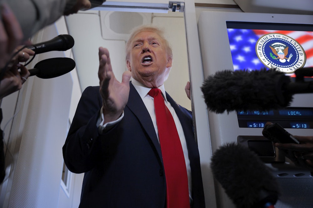 Donald Trump talks to reporters on board Air Force One.