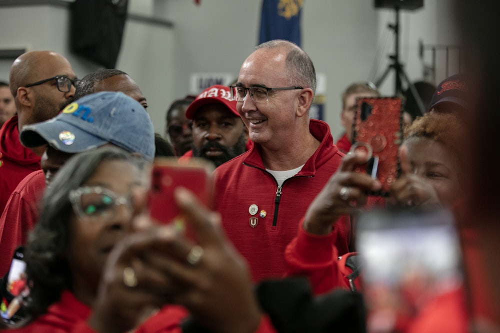 Shawn Fain smiles, surrounded by others.