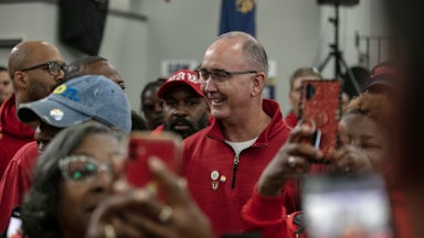 Shawn Fain smiles, surrounded by others.