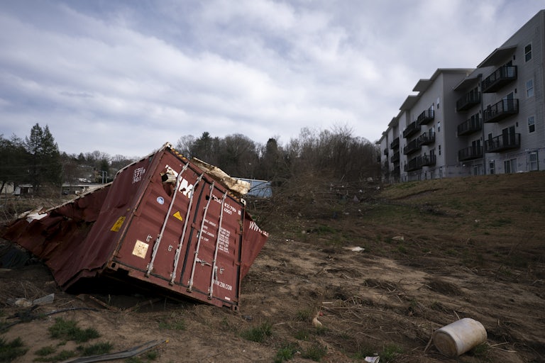 A crushed shipping container sits along the Swannanoa River in a landscape scarred by Hurricane Helene on March 24, 2025, in Asheville, North Carolina.