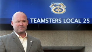 Teamsters President Sean O’Brien stands in front of a sign that reads “Teamsters Local 25”