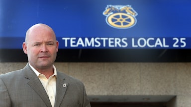Teamsters President Sean O’Brien stands in front of a sign that reads “Teamsters Local 25”