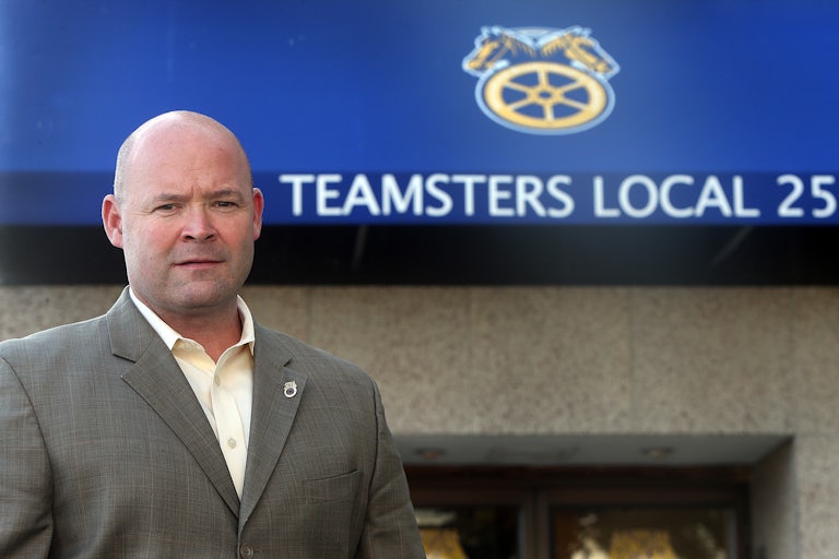 Teamsters President Sean O’Brien stands in front of a sign that reads “Teamsters Local 25”
