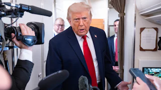 Donald Trump leans forward while speaking to reporters on Air Force One