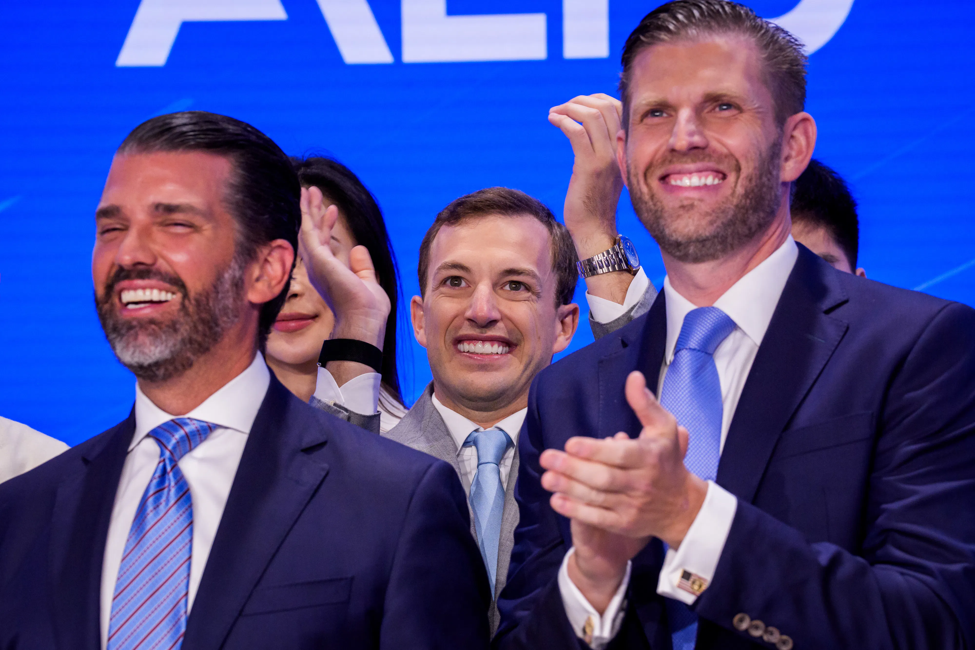 Donald Trump Jr. and Eric Trump smile and clap after ringing the Nasdaq opening bell.