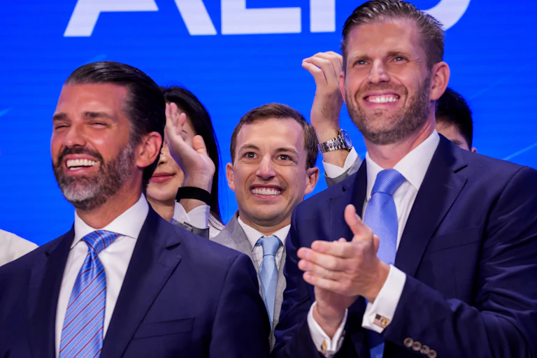 Donald Trump Jr. and Eric Trump smile and clap after ringing the Nasdaq opening bell.