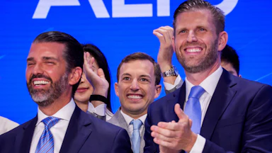 Donald Trump Jr. and Eric Trump smile and clap after ringing the Nasdaq opening bell.