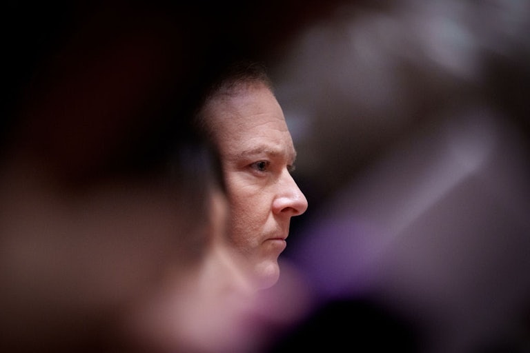 Lee Zeldin's face is seen in profile between the blurs of other objects.