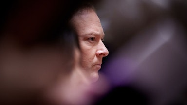 Lee Zeldin's face is seen in profile between the blurs of other objects.