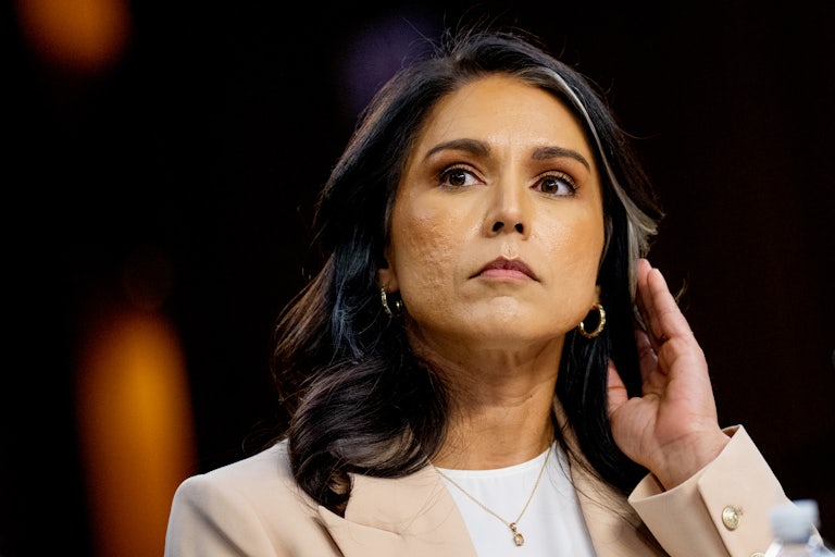 Tulsi Gabbard touches her hair while sitting in a Senate committee hearing