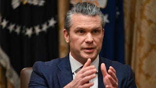 Defense Secretary Pete Hegseth gestures and speaks while sitting in Donald Trump's cabinet meeting
