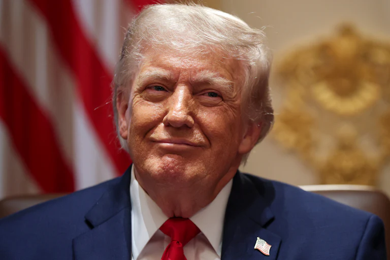 Donald Trump smiles while sitting in a Cabinet meeting