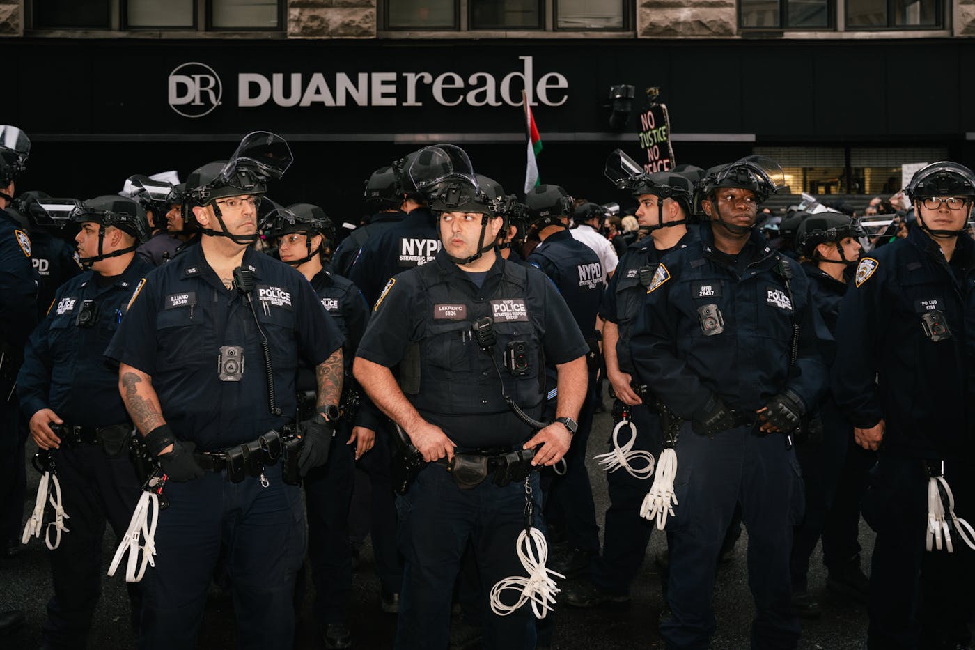 A line of police with zip ties attache to their belts waiting for protesters in New York City on Sunday at the No Kings event 