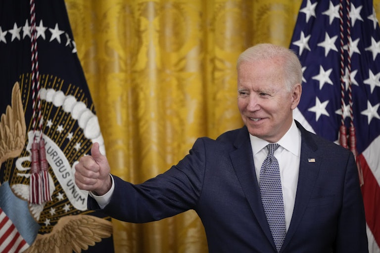 President Joe Biden flashes a thumbs up at the White House.