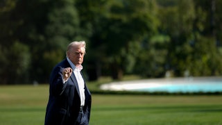 Donald Trump raises his fist while walking outside the White House