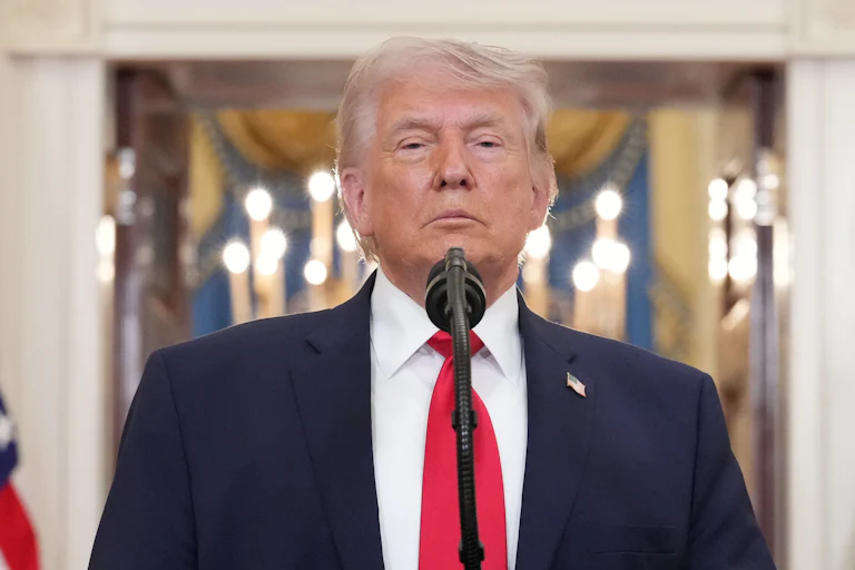 Donald Trump stands at a microphone