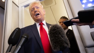 President Donald Trump speaks with the media as Defense Secretary Pete Hegseth looks on aboard Air Force One