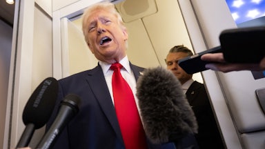 President Donald Trump speaks with the media as Defense Secretary Pete Hegseth looks on aboard Air Force One