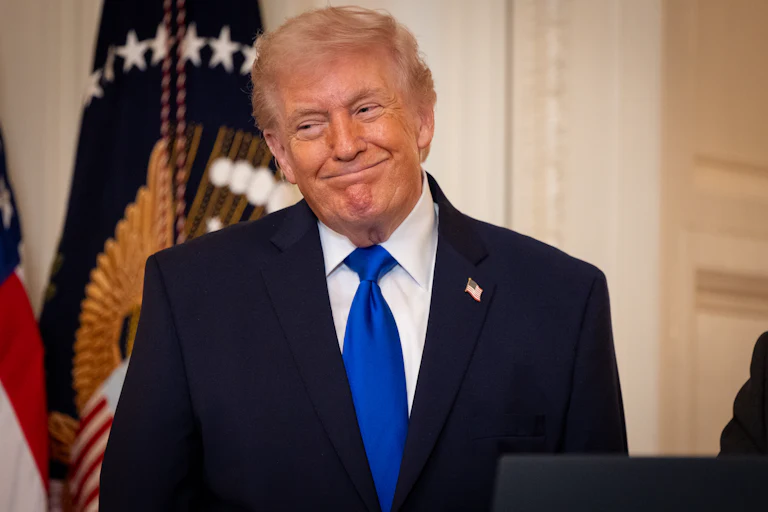 Donald Trump smiles while standing during an event