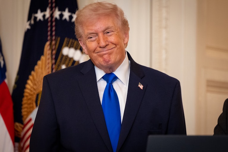 Donald Trump smiles while standing during an event