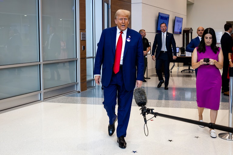 Donald Trump speaks to reporters as he walks down a hallway