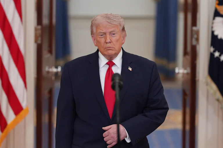 President Donald Trump stands at a microphone in the White House.