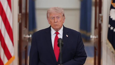 President Donald Trump stands at a microphone in the White House.