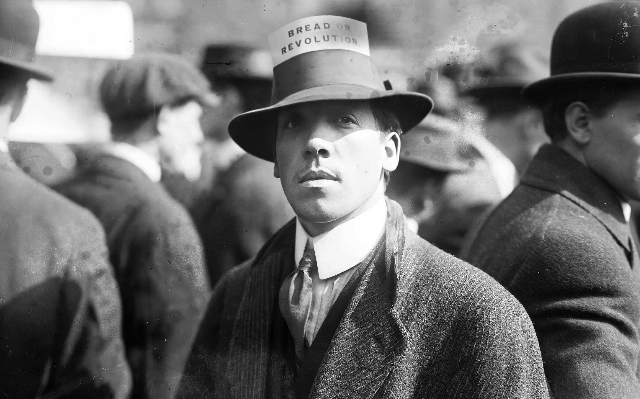 A man wearing a hat with a card that reads 'Bread Or Revolution' during a rally in New York's Union Square, April 1914. 
