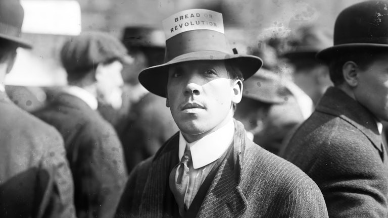 A man wearing a hat with a card that reads 'Bread Or Revolution' during a rally in New York's Union Square, April 1914.