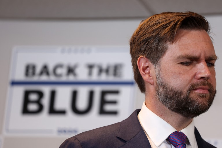 J.D. Vance looks down while at a Donald Trump campaign event
